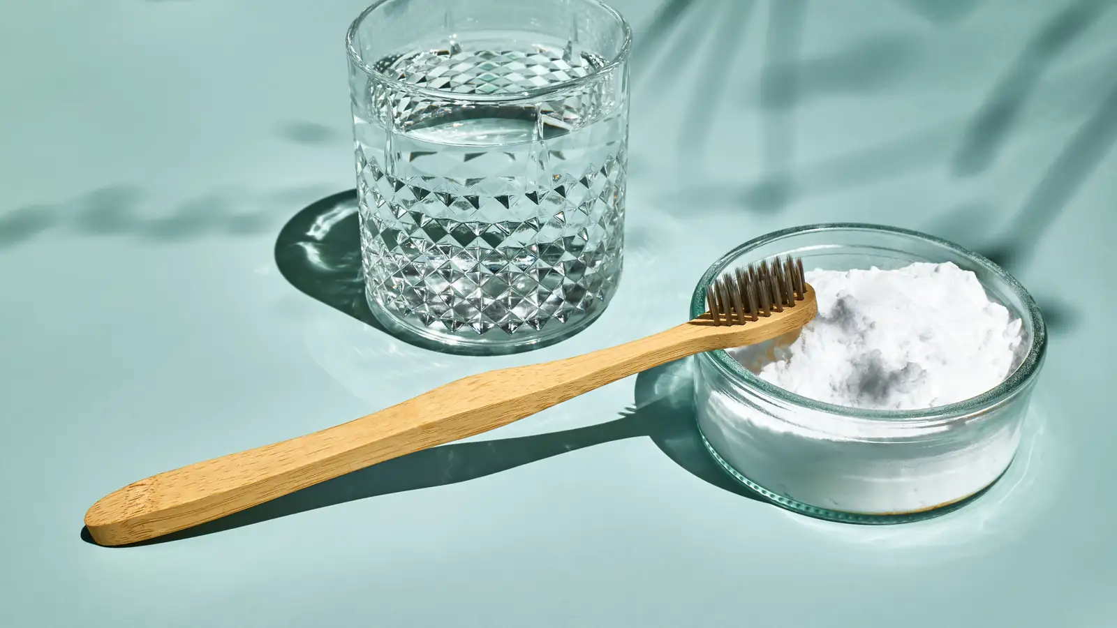 Cam kasede karbonat, bambu diş fırçası ve bir bardak su
